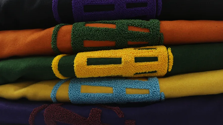 Five chenille crests on stacked varsity jackets