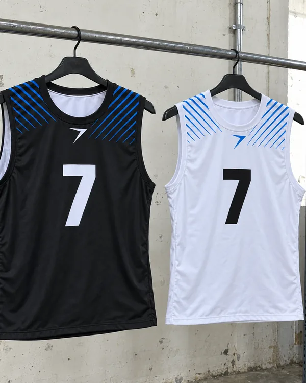 A black 7v7 top with a white 7 and a white one with a black 7, on hangers, with blue stripes at the shoulders