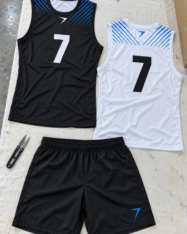 The GOAL LINE kit laid flat: a black 7v7 top with a white 7, a white one with a black 7, and black shorts