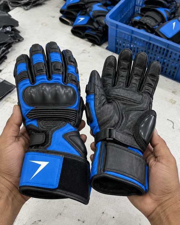 Hands hold up two blue and black race gauntlets, one showing its knuckle guard and one its palm slider