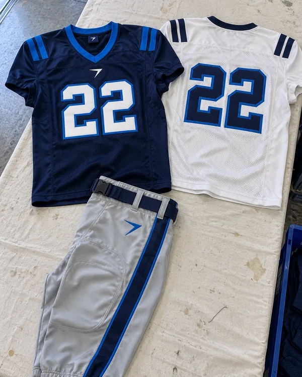 The HASHMARK uniform laid flat: a navy home jersey with a white 22, a white away jersey with a navy 22, and silver pants with a navy stripe