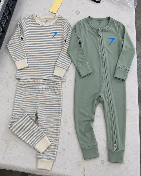 LULL pajamas laid flat: a striped snug-fitting set and a sage zip sleeper with fold-over cuffs