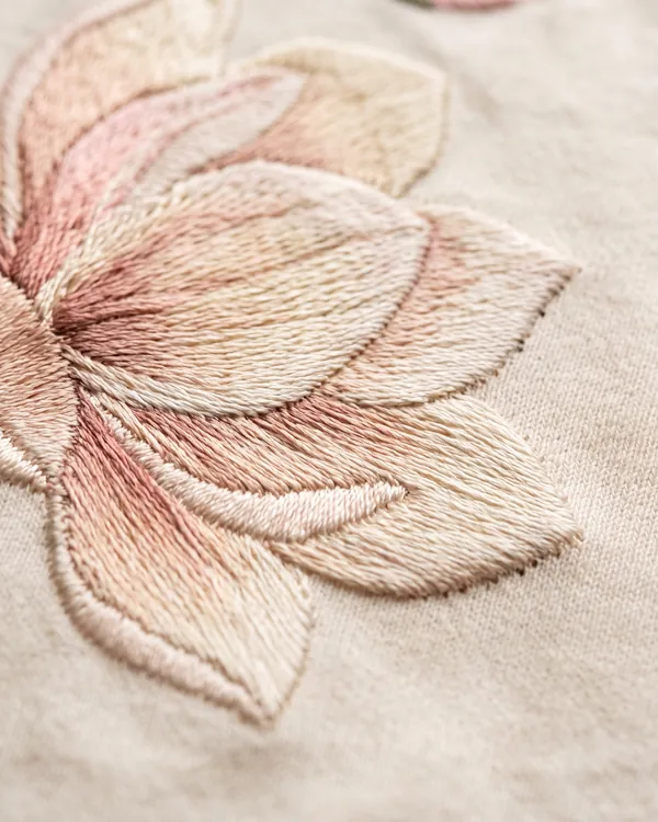 Thread painted magnolia petals on cream fabric
