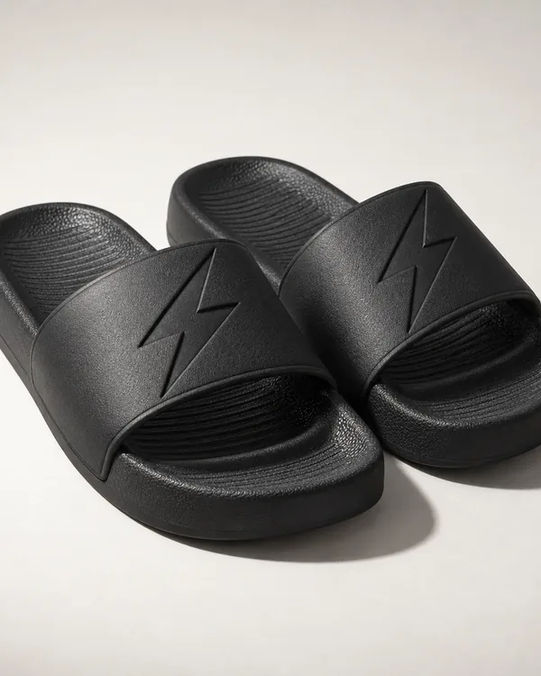 Pair of black slides with a debossed bolt on each strap