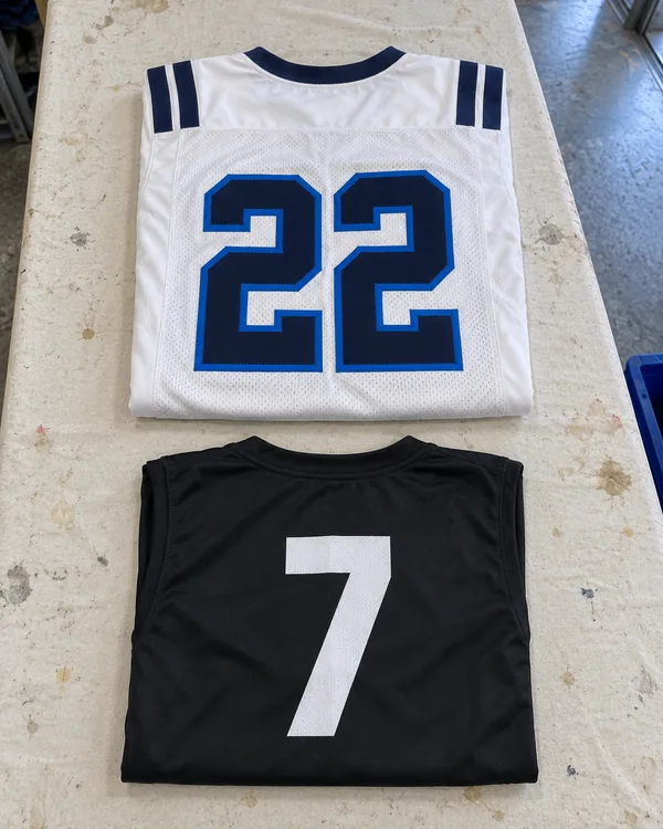 A white football jersey with a stitched tackle twill 22, above a black 7v7 top with a flat white 7 dyed in