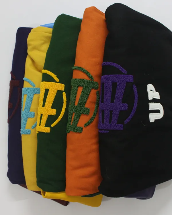 Five Fince Up varsity jackets stacked, one in each colorway