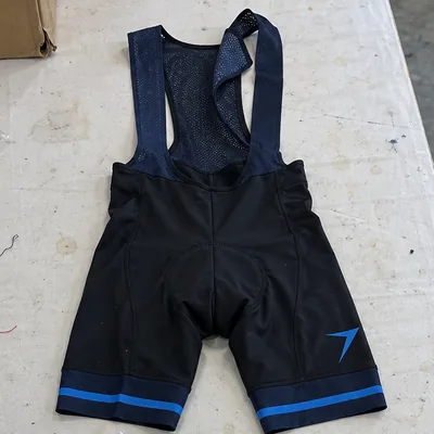 Black bib shorts with navy straps, a blue bolt on the thigh and blue striped leg bands