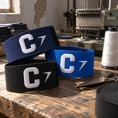 Navy, blue and black captain armbands, each with a white C and a bolt