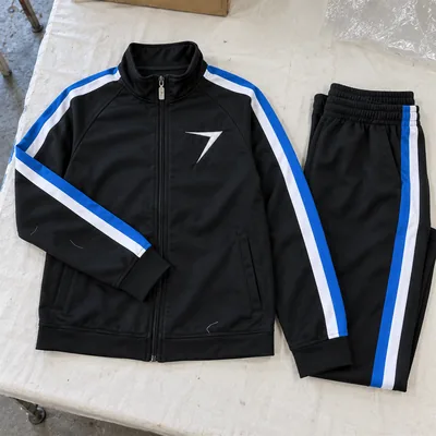 Black warm-up jacket and pants with blue and white stripes down the sleeves and legs, and an embroidered bolt
