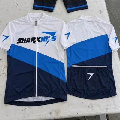 Two CADENCE cycling jerseys, front and back, white and blue with SHARKNITS across the chest