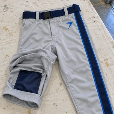 Silver football pants with a navy stripe, one leg rolled up to show the knee pad pocket inside