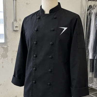 A black double-breasted chef coat with fabric knot buttons and a white bolt on the chest, on a dress form