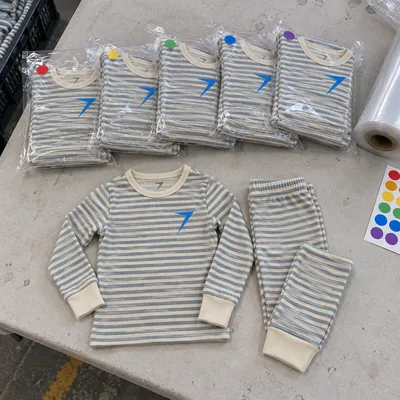 Striped snug-fitting kids pajama sets in clear bags, with one set laid out in front