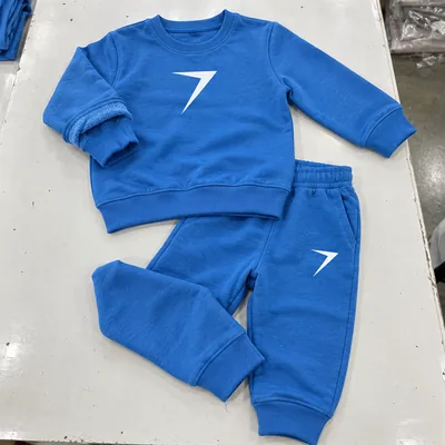 A blue kids sweatshirt and joggers with white bolts, laid flat