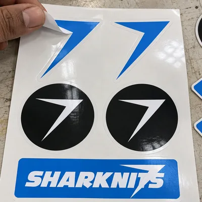 A sheet of six stickers, with a blue bolt sticker peeled halfway off