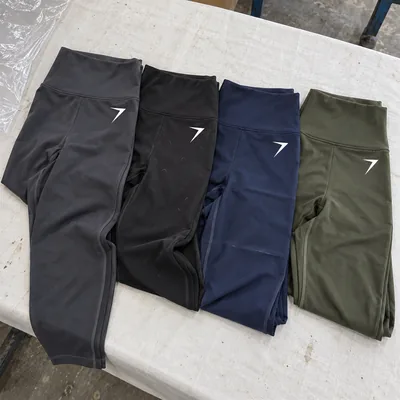 Four pairs of high-rise leggings in charcoal, black, navy and olive, each with a white bolt on the hip