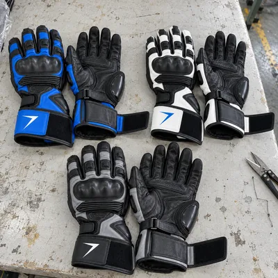 Race gauntlets in blue, white and gray, each with a knuckle guard and a long cuff