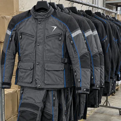 Charcoal textile riding jackets with blue piping on a factory rail