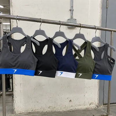 Five sports bras on hangers, charcoal, black, navy and olive, with a bolt on each band